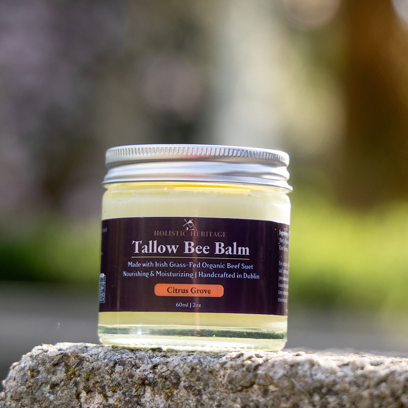Citrus Grove Tallow Bee Balm by Holistic Heritage – glass jar of grass-fed Irish skincare photographed outdoors on stone.